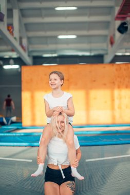 Anne ve kızı parkında oynarken. Anne boynunda oturan kız