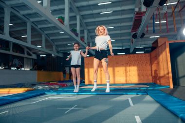 Anne ve kızı trambolin üzerinde atlama ve split yapıyor
