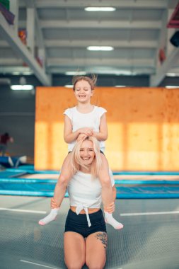 Anne ve kızı parkında oynarken. Anne boynunda oturan kız
