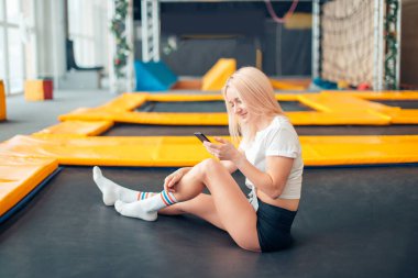 Beyaz kadınlar akıllı telefonunu trambolin ile oynamak