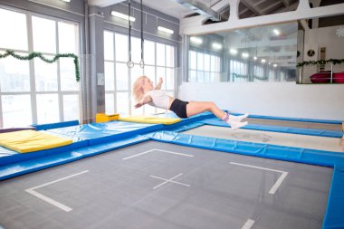 Genç kadın trambolin üzerinde atlama sicim