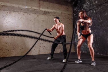 Kadın ve erkek çift eğitim savaş ip egzersiz yaparken birlikte