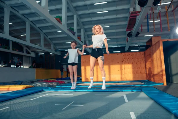 Moeder en dochter springen op de trampoline en split doen — Stockfoto