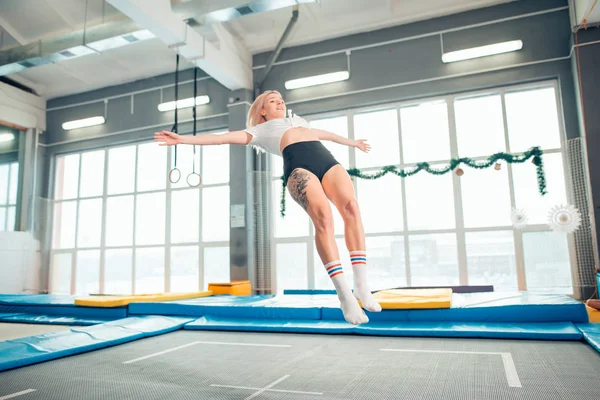 Twine jumping jovem mulher no o trampolim — Fotografia de Stock