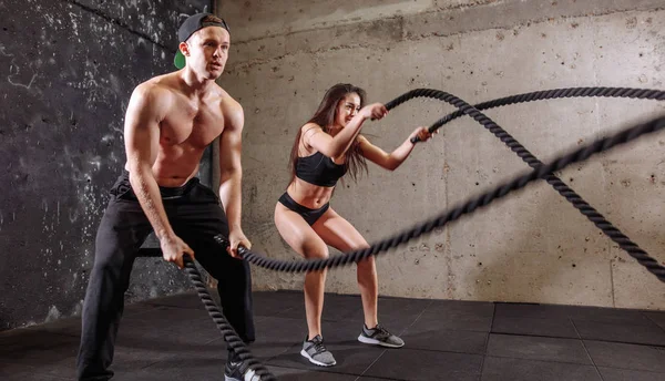 Mujer y hombre pareja entrenando juntos haciendo entrenamiento de cuerda de batalla — Foto de Stock