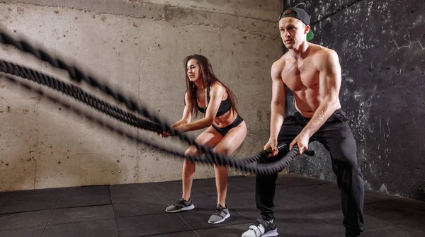 Mujer y hombre pareja entrenando juntos haciendo entrenamiento de cuerda de batalla — Foto de Stock