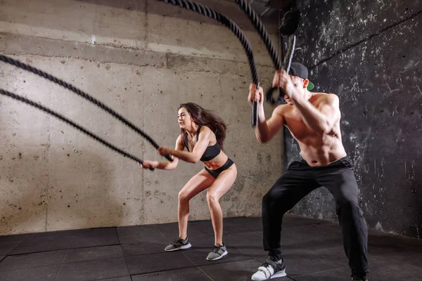 Woman and man couple training together doing battling rope workout — Stock Photo, Image