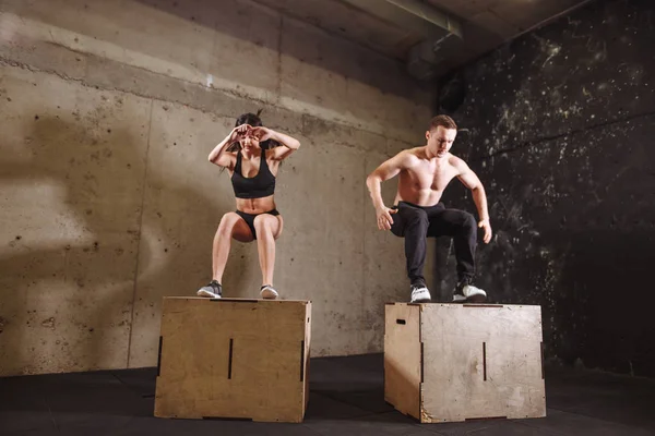 Mies ja nainen hyppäämällä fit box — kuvapankkivalokuva