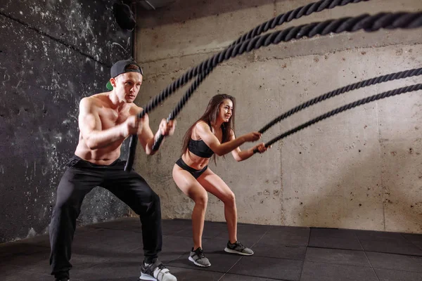 Mujer y hombre pareja entrenando juntos haciendo entrenamiento de cuerda de batalla — Foto de Stock