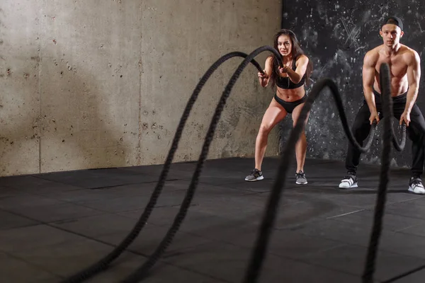 Mujer y hombre pareja entrenando juntos haciendo entrenamiento de cuerda de batalla — Foto de Stock