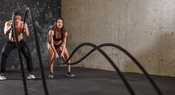 Kobieta i mężczyzna para szkolenia razem robi walczy liny workout — Zdjęcie stockowe