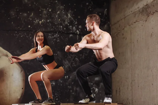 Hombre y mujer saltando en la caja de ajuste — Foto de Stock