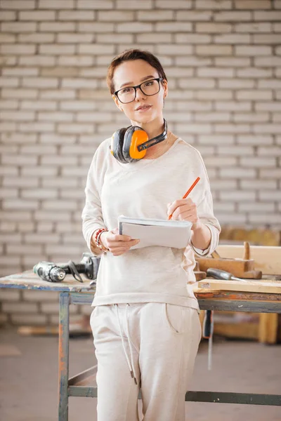 Trabajadora profesional con pluma y tableta en el taller — Foto de Stock