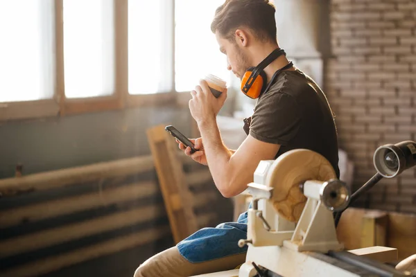 Hombre usando el teléfono inteligente y sosteniendo la taza de café — Foto de Stock