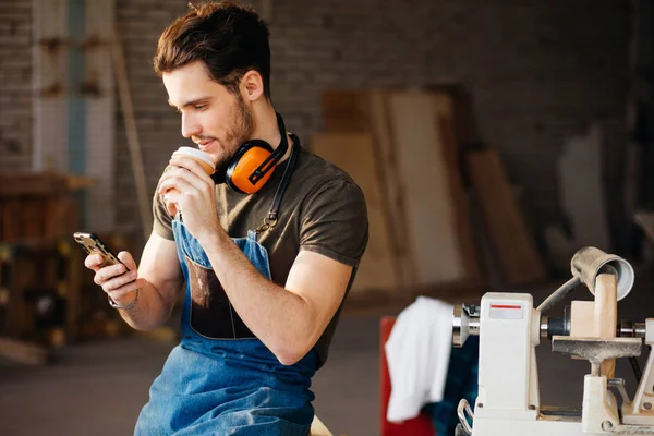 Man using smart phone and holding cup of coffee — Stock Photo, Image