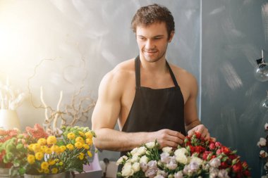 ışık çiçek dükkanında çalışan güçlü erkeğin gülümseyen