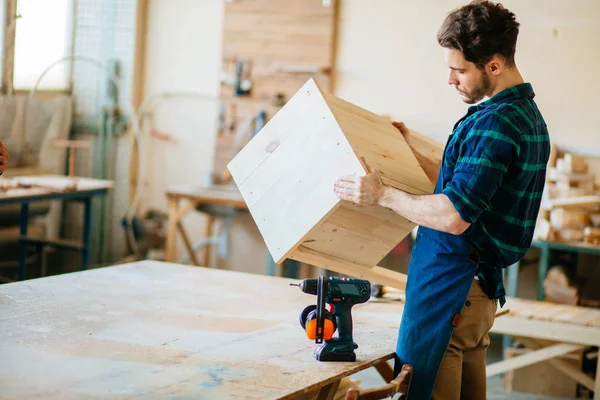 Carpenter testing wood plank evenness at workshop — Stock Photo, Image