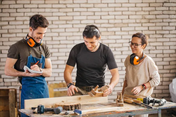Тесля зі студентами в деревообробній майстерні — стокове фото