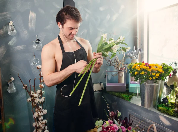 man with brown hair creating composition at flower shop