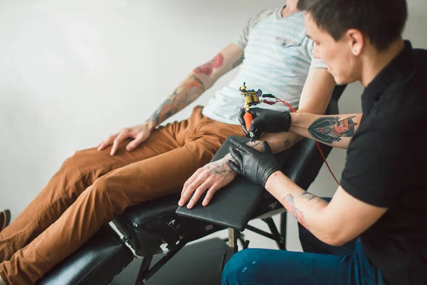 Tattoo kunstenaar maakt tattoo aan kant — Stockfoto