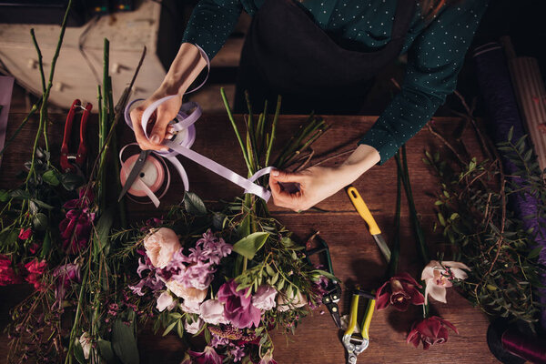 closeup shot of process of tighting ribbon on flowers