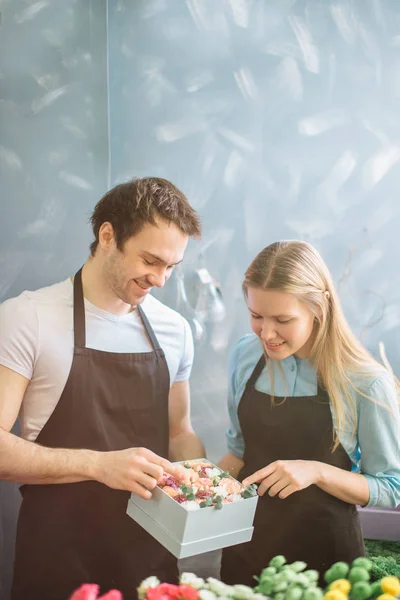 Foto de miradas encantadoras de dos floristas en el interior — Foto de Stock