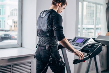 Ems eğitim salonunda treadmill çalışan siyah elbiseli adam
