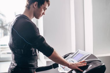 Ems eğitim salonunda treadmill çalışan siyah elbiseli adam