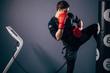 adam eğitim diz vuruş. Elektrik stimülasyon takım elbise giyen bir kick boks