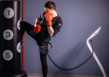 adam eğitim diz vuruş. Elektrik stimülasyon takım elbise giyen bir kick boks