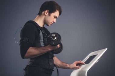 dambıl ile ayakta elektrik kas stimülasyonu elbiseli adam