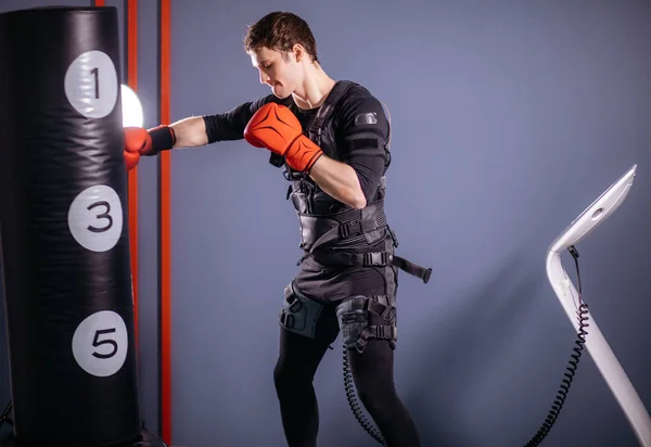 Hombre con guantes de boxeo durante el entrenamiento. boxeador en traje de estimulación eléctrica —  Fotos de Stock