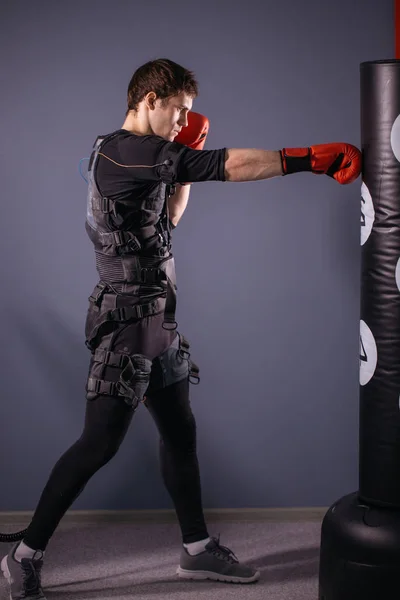 Man in bokshandschoenen tijdens de training. bokser in pak van elektrische stimulatie — Stockfoto