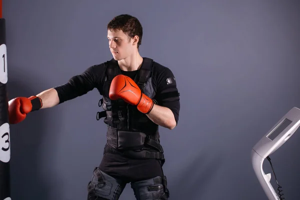 Man in bokshandschoenen tijdens de training. bokser in pak van elektrische stimulatie — Stockfoto