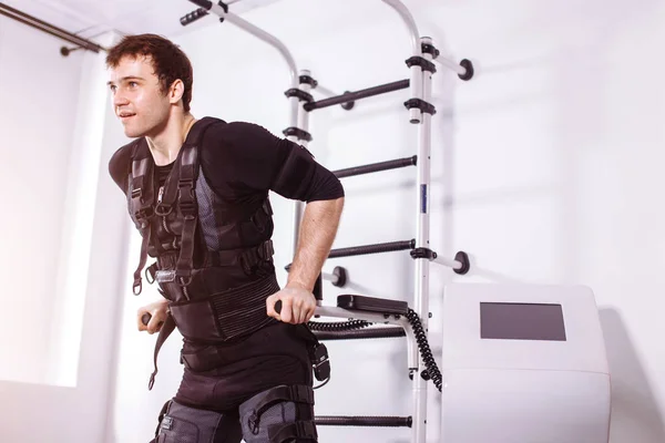 EMS manliga arbetande ute, göra push ups. man gör triceps dips på barr — Stockfoto