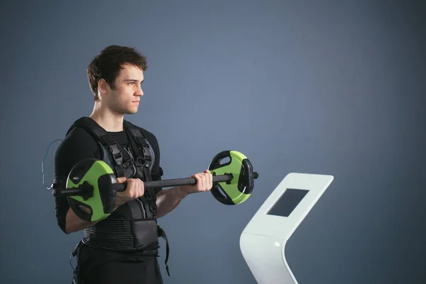 Man working out EMS training with barbell closeup, power pose — Stock Photo, Image