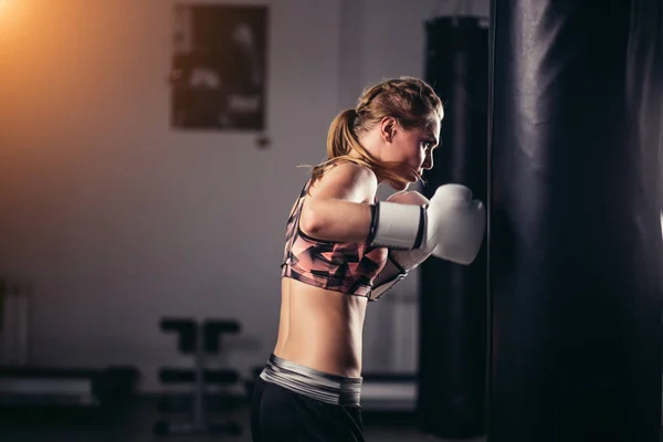 Luchador chica usando ropa deportiva saco de boxeo —  Fotos de Stock