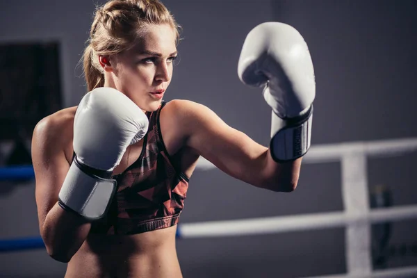Женщина-боксер в перчатках позирует в боксерской студии — стоковое фото