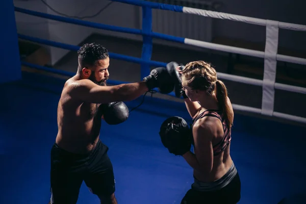 Sportlicher muskulöser junger Mann und Frau boxen vereinzelt auf schwarz — Stockfoto