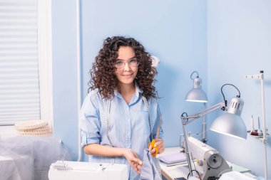 kamera atölye bakarak dalgalı saçlı güzel terzi