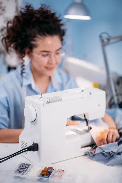 Große Perlen und bunte Knöpfe vor dem Motion-Blur-Bild des Schneiders — Stockfoto