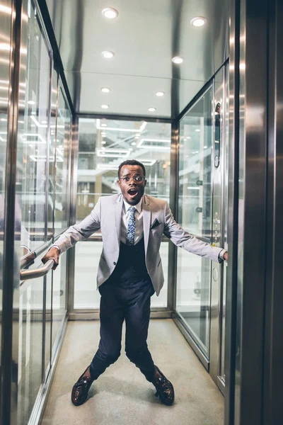 Afrikanischer Geschäftsmann schreit im Fahrstuhl. Angst vor Klaustrophobie — Stockfoto