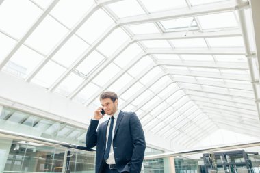 Çalışmak için yolda cep telefonunda konuşurken yürüyüş iş adamı