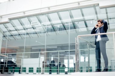 Çalışmak için yolda cep telefonunda konuşurken yürüyüş iş adamı