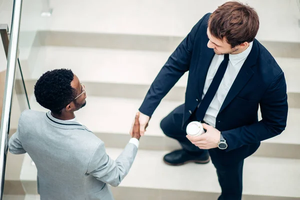 Dois empresários multirraciais aperto de mão no escritório moderno para o fim de muito — Fotografia de Stock