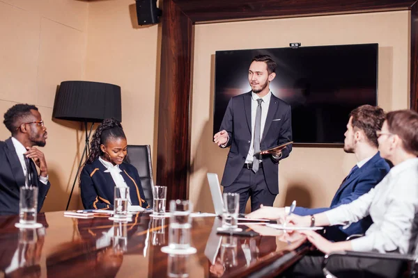 Un homme d'affaires présente à ses collègues lors d'une réunion — Photo