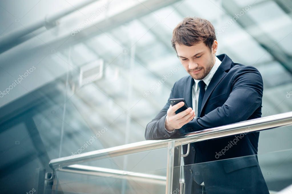 businessman with smartphone over office building