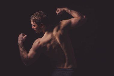 onun mükemmel vücut siyah arka plan üzerinde gösterilen profesyonel vücut geliştirmeci