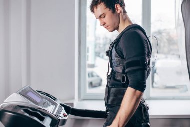 Ems eğitim salonunda treadmill çalışan siyah elbiseli adam