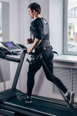 Ems eğitim salonunda treadmill çalışan siyah elbiseli adam